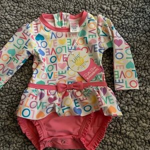 Ruffle Butts NWT 6-12m 1 pc rash guard swimsuit .  Love/hearts theme rufflebutts
